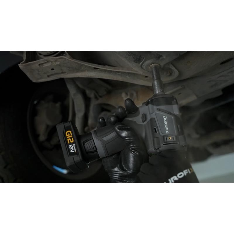 Person using a power drill on a vehicle's undercarriage
