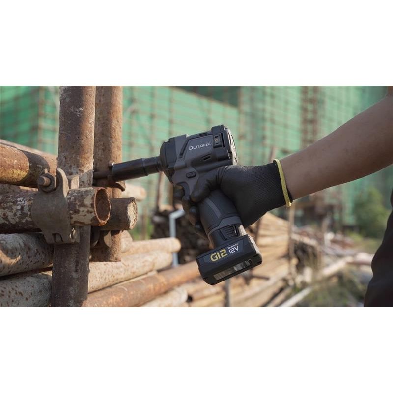 Person using a cordless impact driver on metal pipes with a blurred background