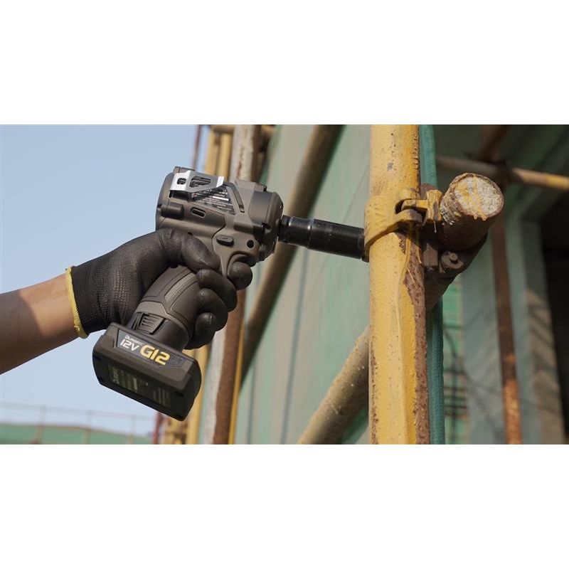Hand using a cordless drill on a metal pipe with a blurred background